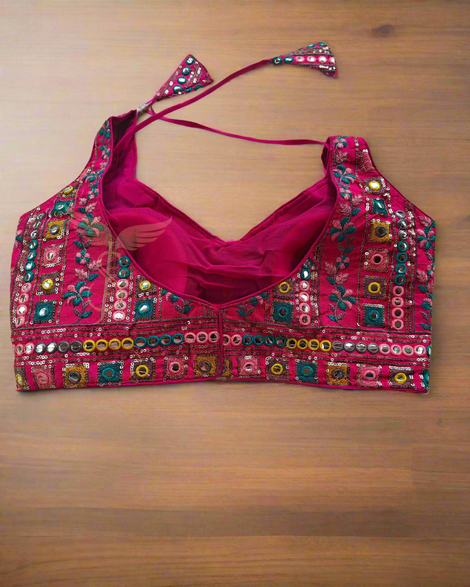 Decorative pink blouse with colorful embroidery on a pink fabric background