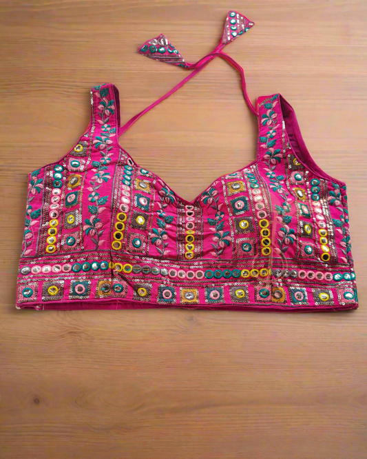 Colorful embroidered pink bralette on a textured white background